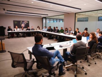 UM students sitting in a large conference room with ESPN and Disney employees at one end of the tables.